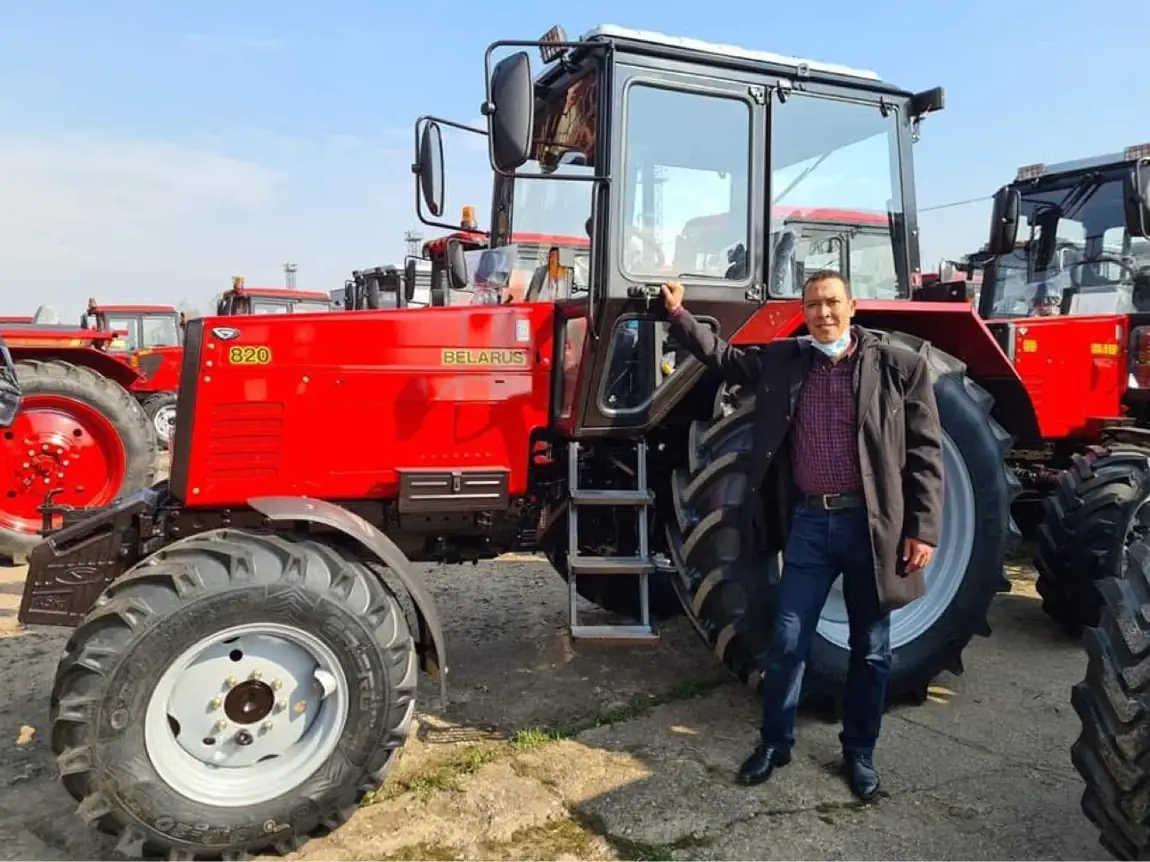Owner of El-Adawy beside a red BELARUS 820 tractor at the MTZ factory yard in Belarus