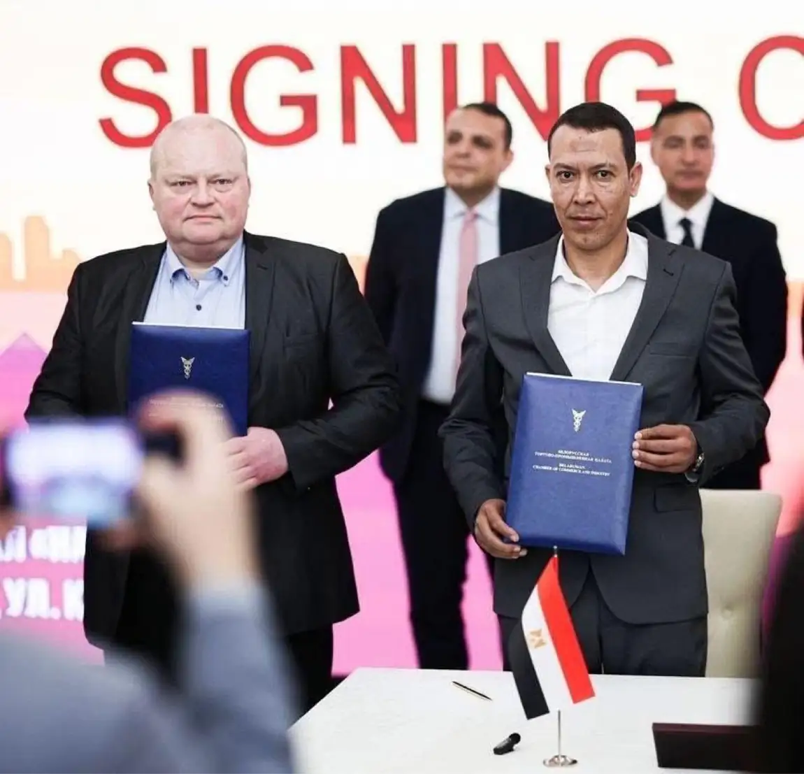 El-Adawy and the Belarusian partner holding the signed agreement folders at the signing ceremony